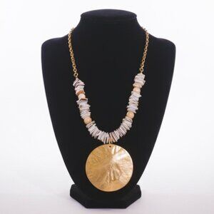 Puka shell statement necklace with gold-toned circular pendant. Brand new.